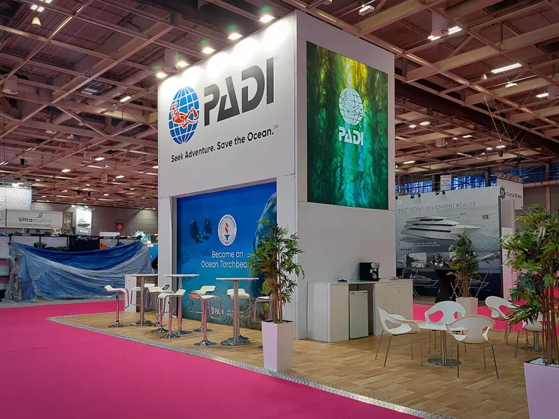 Side view of PADI modular exhibition stand at Paris with backlit logo and seating