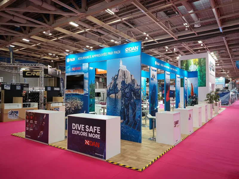 Modular divider showcasing individual PADI collaborators with branded desks and bar stools